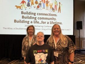 A group of people smiling in front of a presentation at the 2025 Excellence in Life Sharing Awards